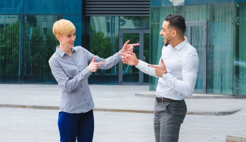 Two business people pointing at each other in front of a building.