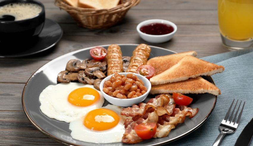 A plate with eggs, sausages, mushrooms and toast.