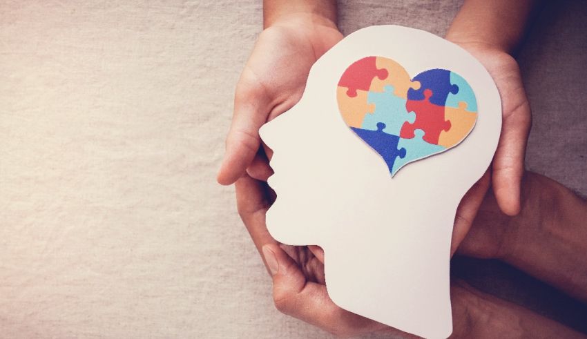 A person's hands holding a heart shaped puzzle piece.