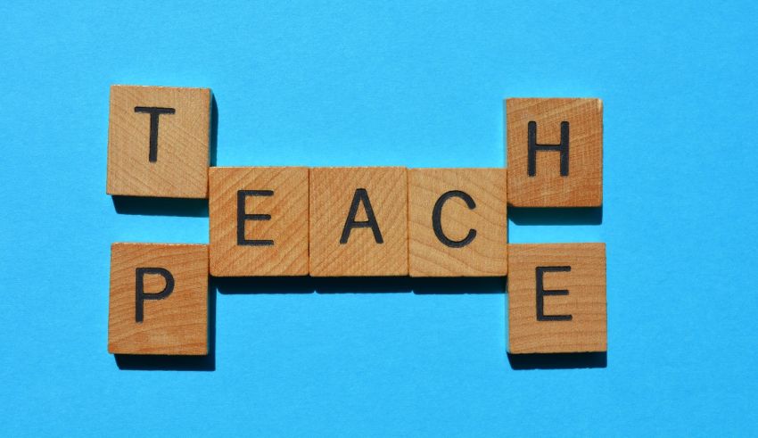 The word teach peace spelled out in wooden blocks on a blue background.