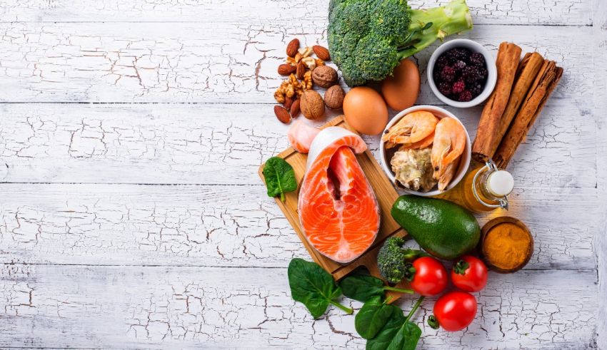 A variety of foods are arranged on a white wooden table.