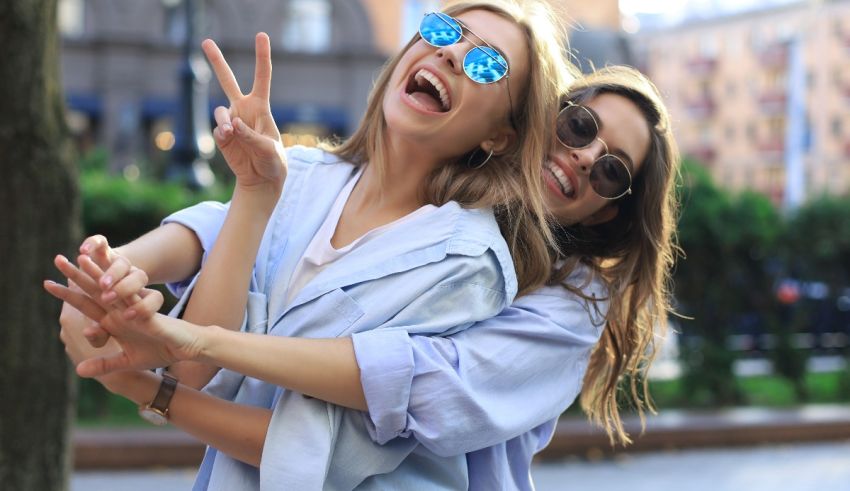 Two young women are hugging each other while making a peace sign.