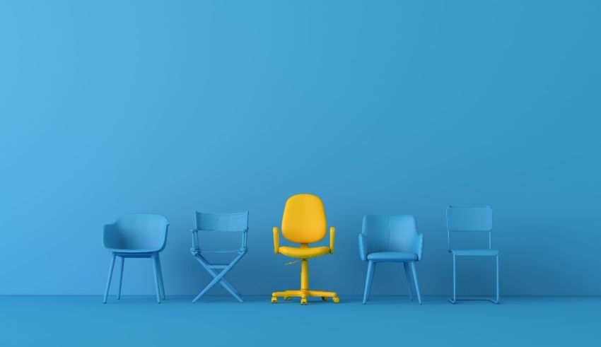 A group of chairs with a yellow chair in the middle.