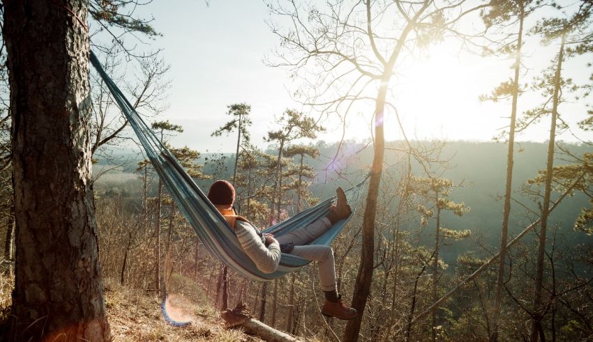 A woman relaxing in a hammock in the woods.