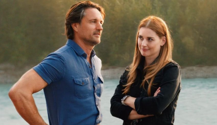 A man and woman standing next to a river.