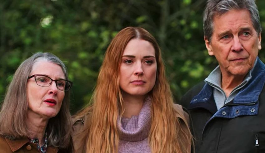 Three people standing next to each other in the woods.