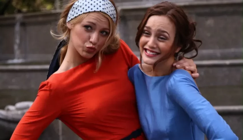 Two women are posing for a picture in front of a building.