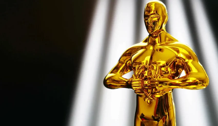 An oscar statue in front of a spotlight.
