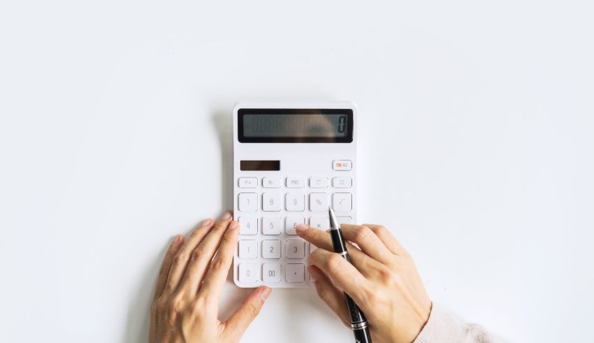 A woman's hand holding a calculator on a white background.