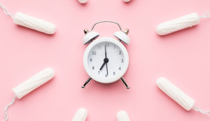 An alarm clock surrounded by toilet paper on a pink background.