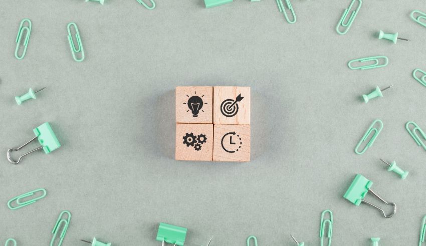 A wooden block surrounded by clipboards and paperclips.