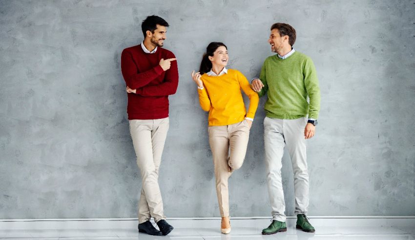 A group of people standing in front of a gray wall.