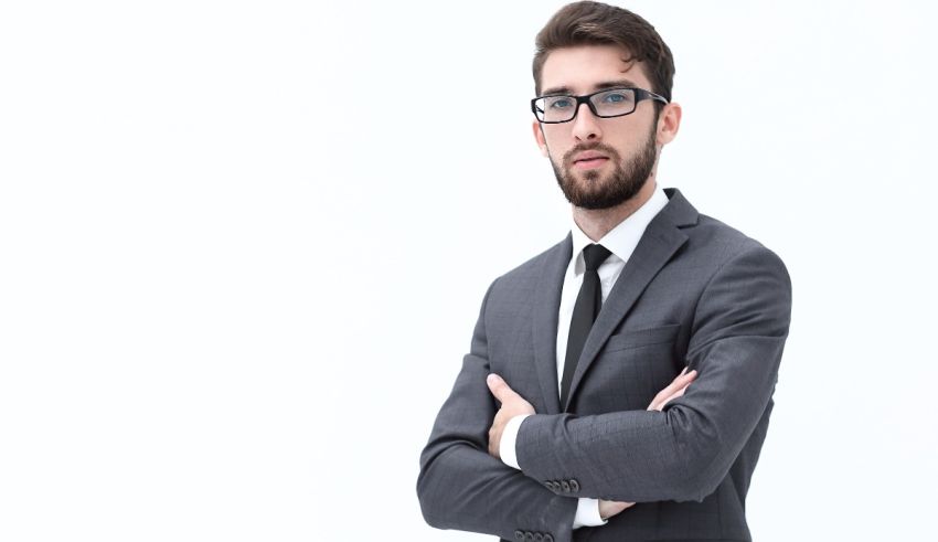 A businessman in a suit and tie posing with his arms crossed.