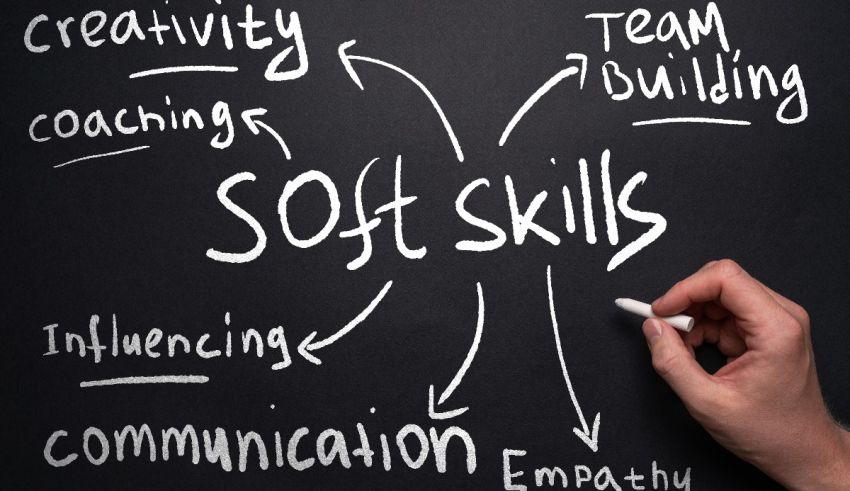 A hand writing the word soft skills on a blackboard.