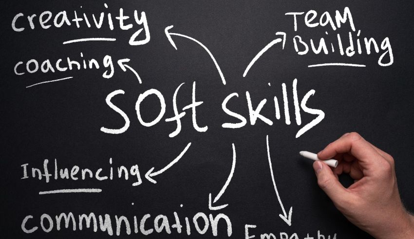 A hand writing the word soft skills on a blackboard.