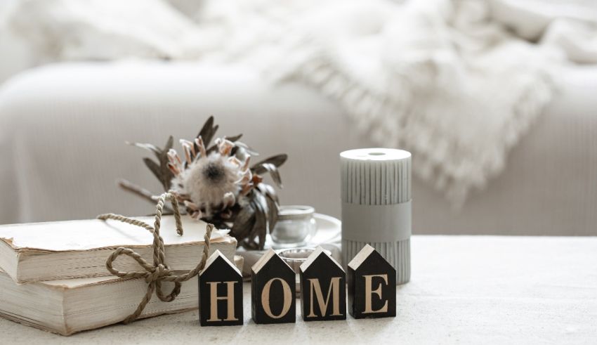 A table with books, a candle, and a home sign.