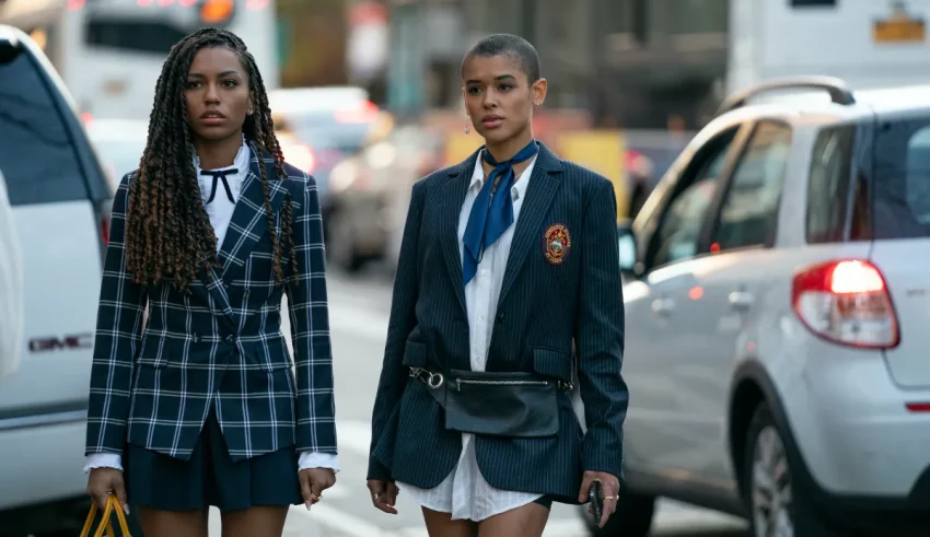 Two young women in school uniforms walking down the street.