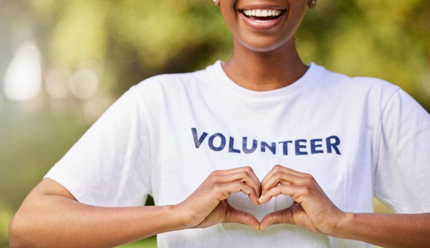 A black woman making a heart with her hands.