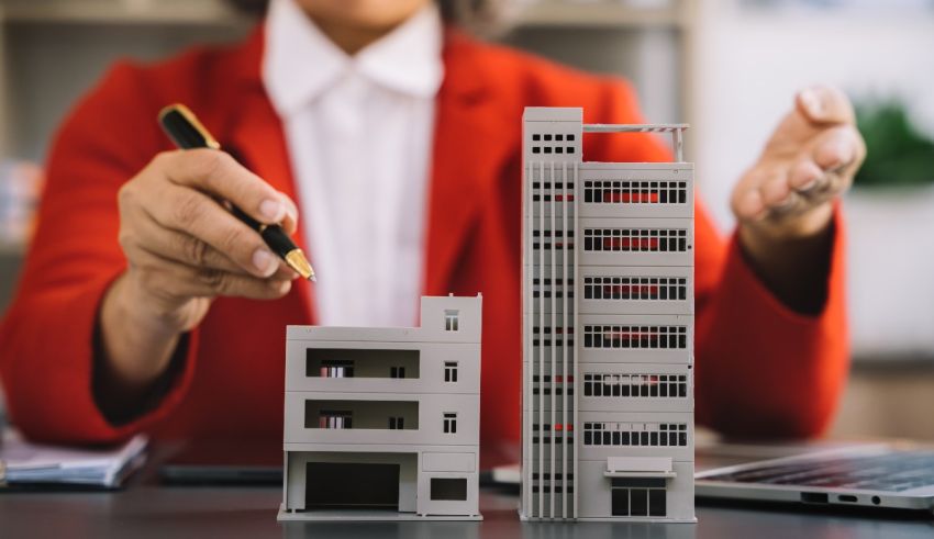 A woman holding a model of a building and a pen.
