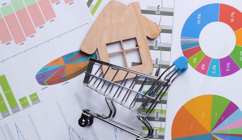 A shopping cart with a model of a house on top of graphs.