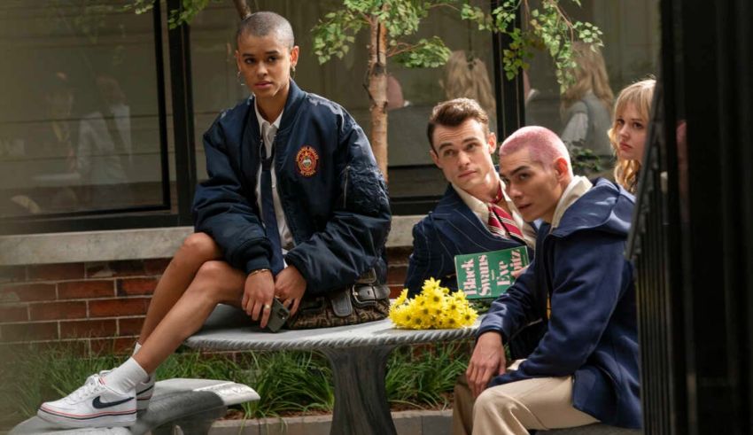 A group of people sitting on a bench in front of a building.