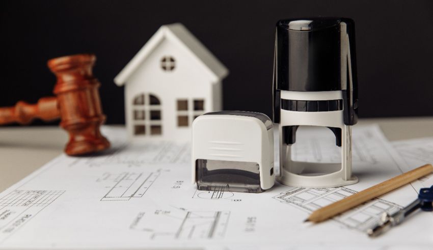 A stamper, a ruler, and a house on a table.