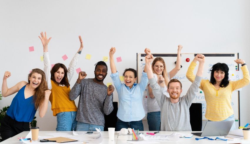 A group of people raising their hands in the office.