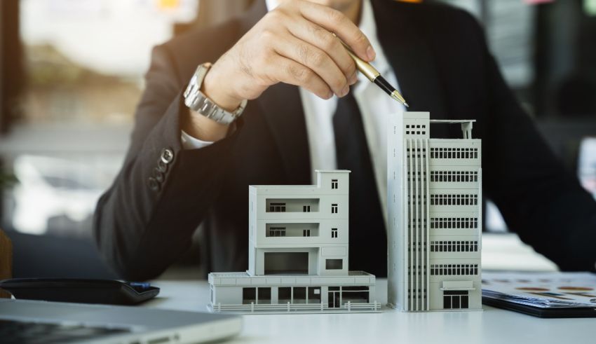 A man in a suit is painting a model of a building.