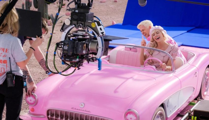 A group of people are sitting in a pink car.