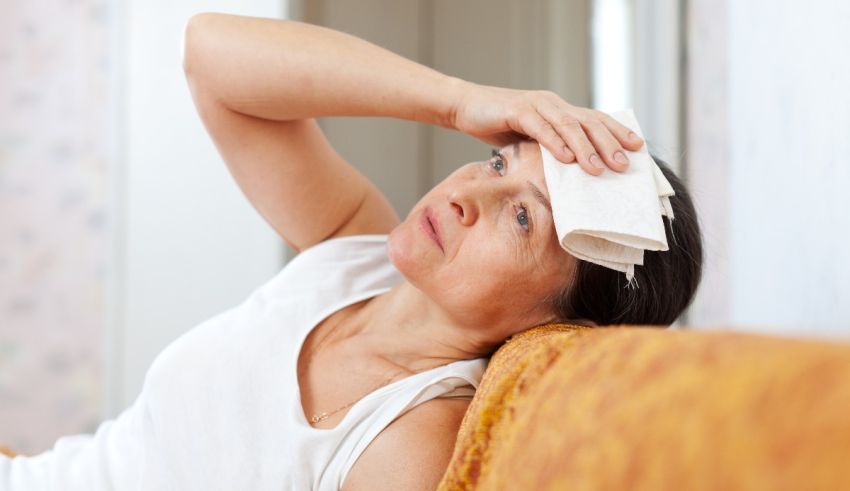 A woman laying on a couch with a towel on her head.