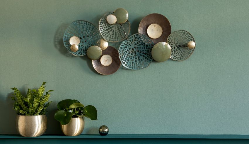 A living room with green walls and a metal plate hanging on the wall.