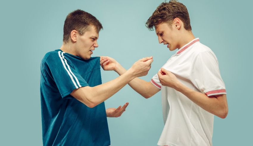 Two young men fighting each other on a blue background.