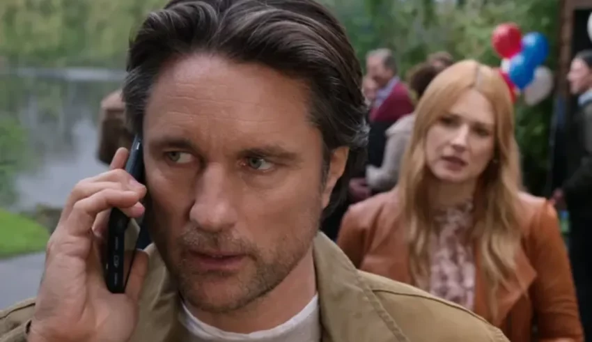 A man talking on a cell phone in front of a group of people.