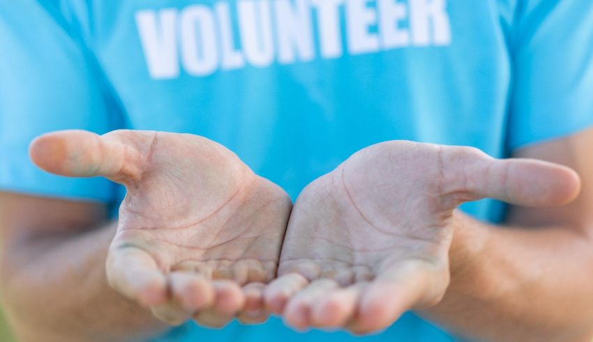 A man's hands with the word volunteer written on them.