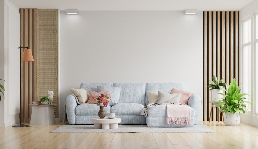 A living room with a blue couch and white walls.