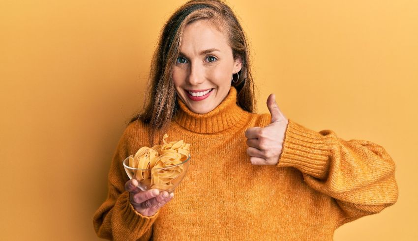 A woman holding a bowl of chips and giving a thumbs up.