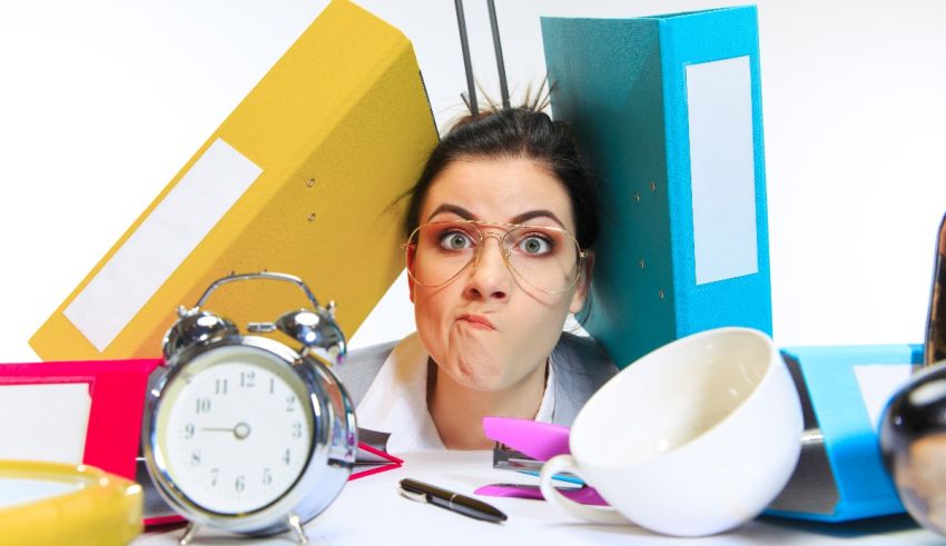 A woman with glasses and a clock in front of a desk.