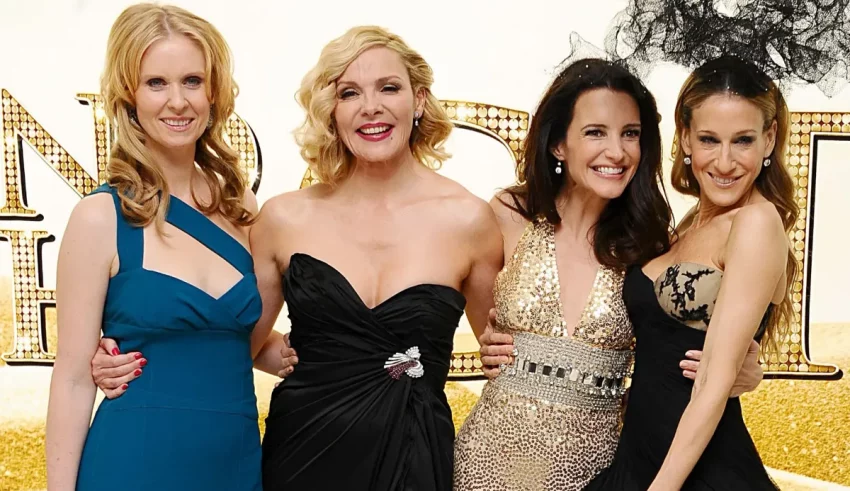 Four women in black dresses posing for a picture.