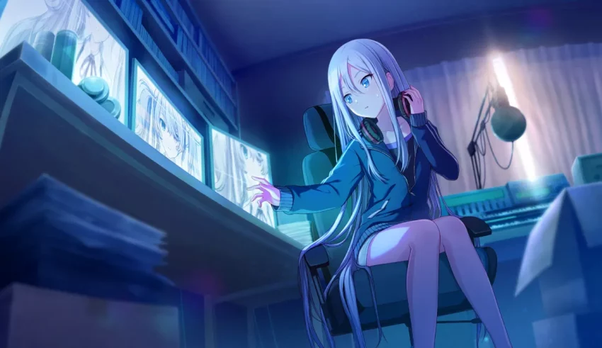 An anime girl sitting at a desk in front of a computer.