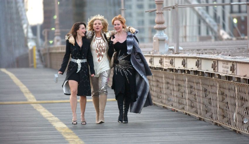 Three women walking on the brooklyn bridge.