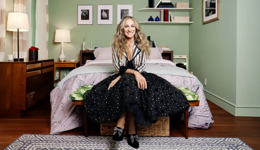 A woman sitting on a bed in a green bedroom.