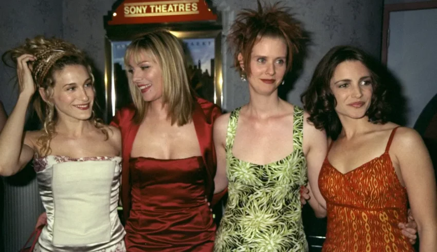 Four women posing for a picture in front of a movie theater.