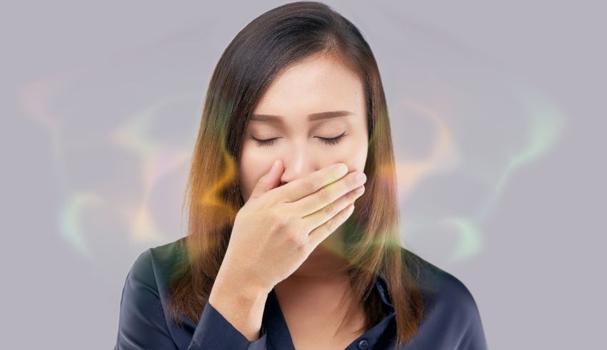 A woman is covering her nose with her hands.