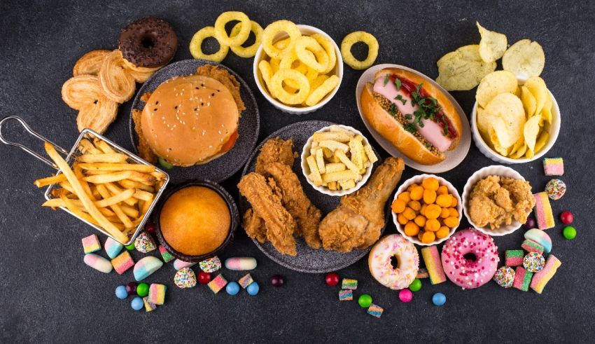 A variety of fast food items are arranged on a dark background.
