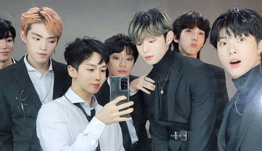 A group of korean boys are taking a selfie.