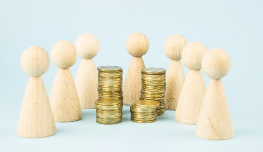 Wooden people standing around a stack of coins on a blue background.