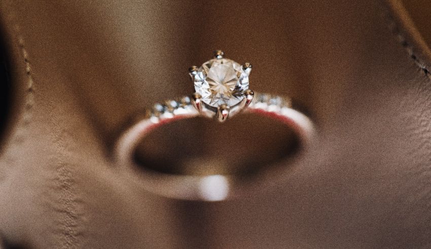 An engagement ring sitting on top of a purse.