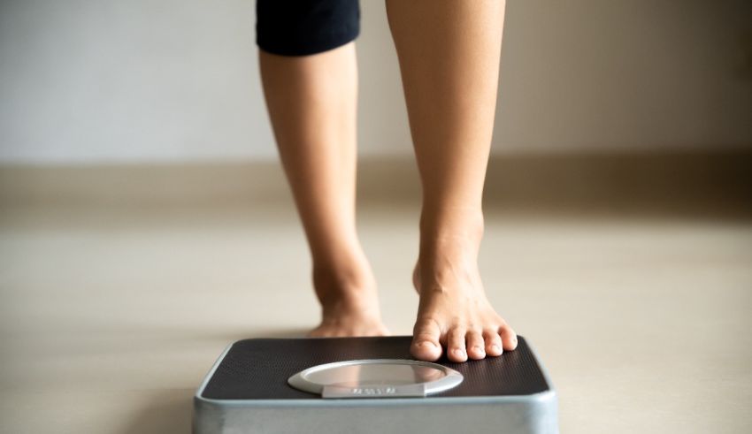 A woman standing on a weight scale.