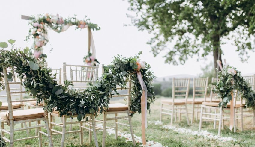 A wedding ceremony set up with chairs and greenery.