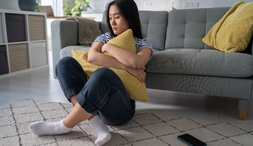 A woman sitting on a couch with a pillow in her lap.